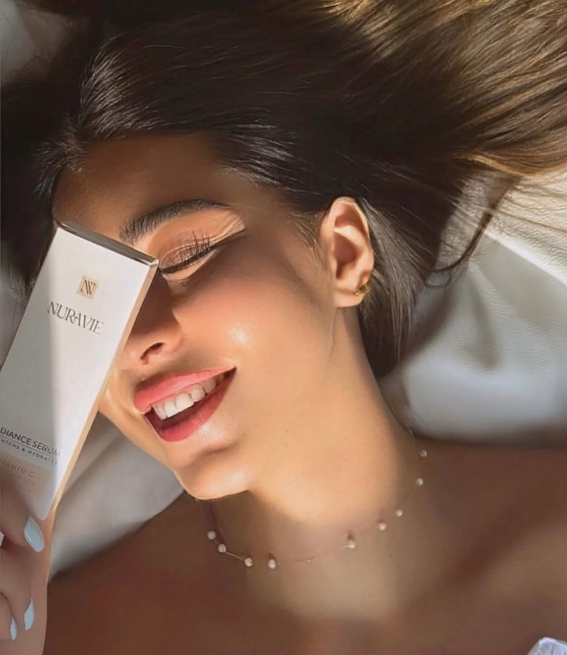 Woman holding a skincare product with a blurred background