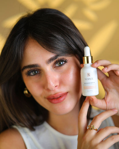 Woman holding a skincare serum bottle with a blurred background